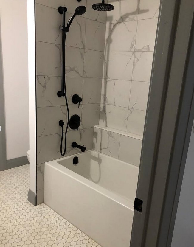 Leaks Plumbing — tub and shower renovation with black fixtures